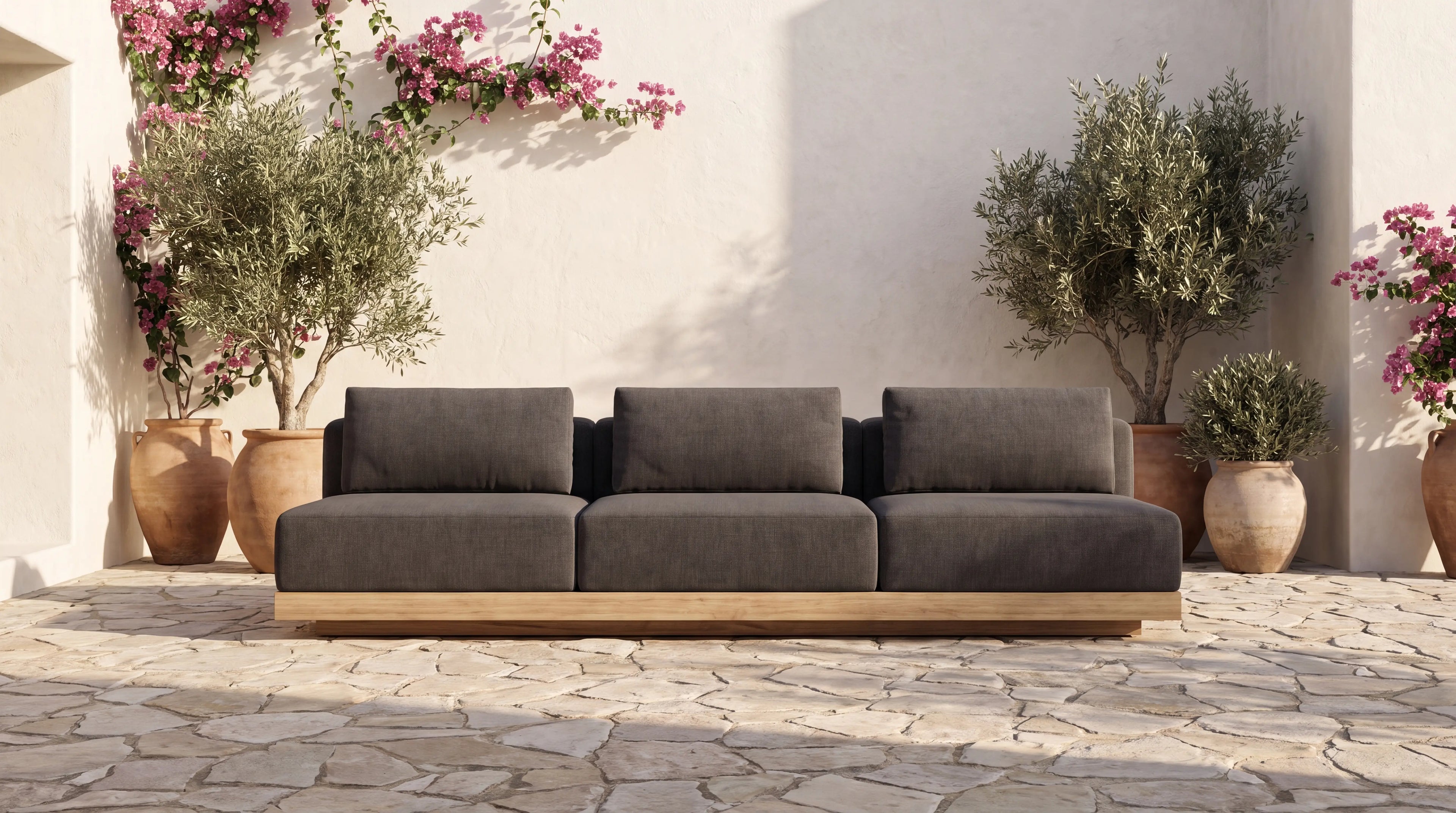 Solis solid teak sofa in a whitewashed Mediterranean courtyard